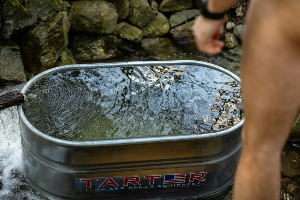 male athlete getting into cold water bath
